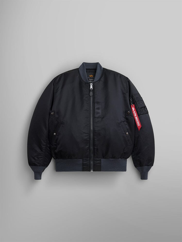 The 1960s MA-1 Bomber Jacket by Alpha Industries in black features a zip-up front, ribbed cuffs, and a signature red tag on the left sleeve.