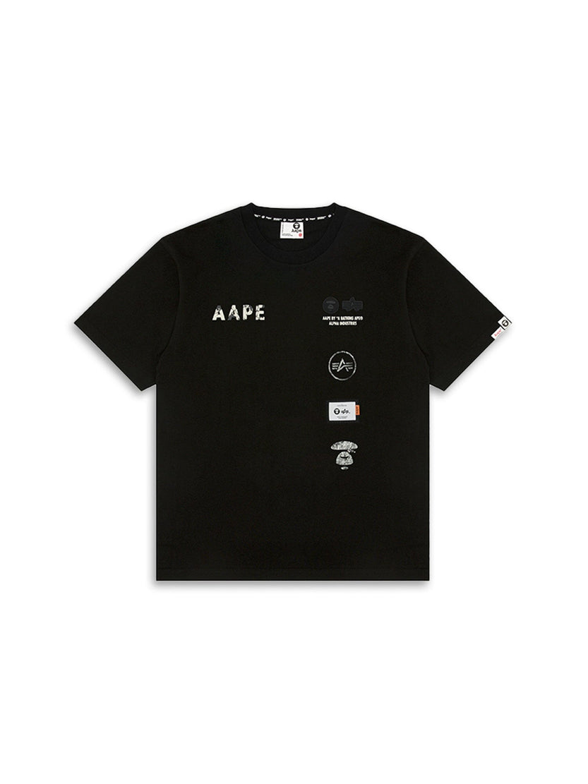 The AAPE X Alpha Somewhere In Universe Tee by Alpha Industries is a black T-shirt with white and grey logo patches and AAPE on the front.