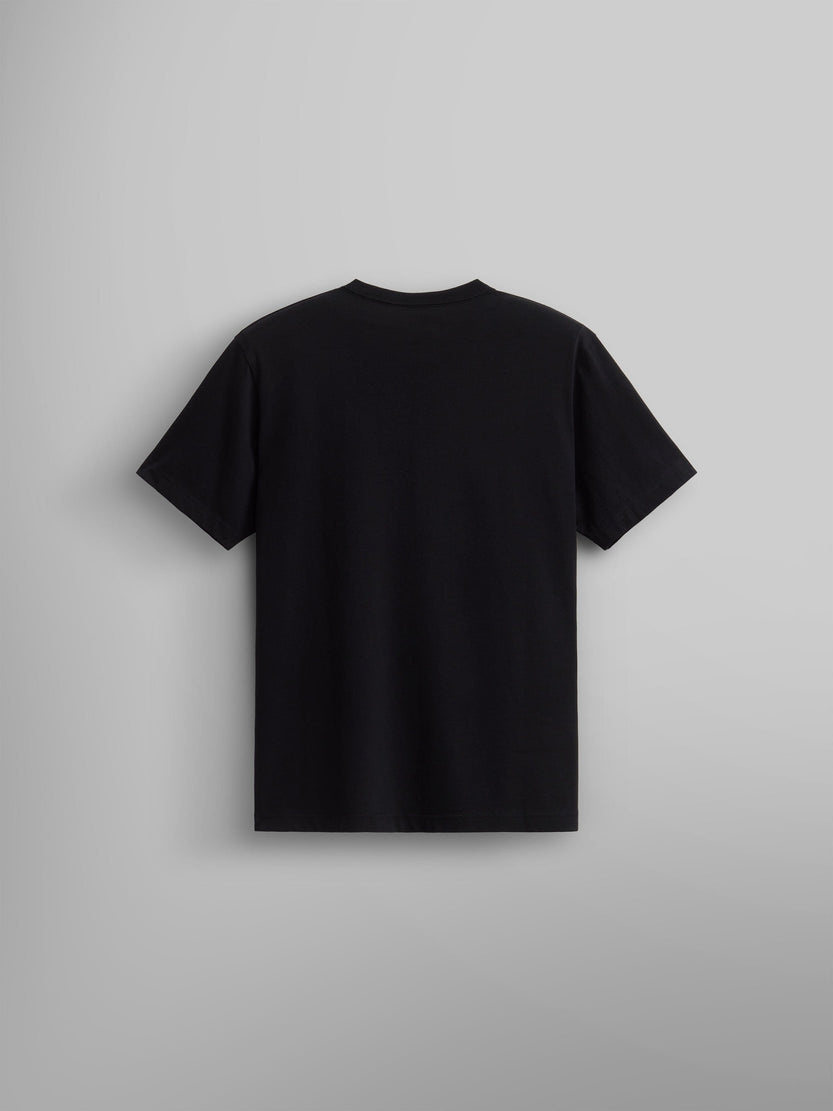 An ALPHA AIR ASSAULT REPEL TEE from Alpha Industries, part of their FW24-DROP1 collection, is showcased against a light gray background. This plain black T-shirt embodies the rugged elegance typical of military icons and is presented from the back, suggesting adventures in air assault and timeless style.