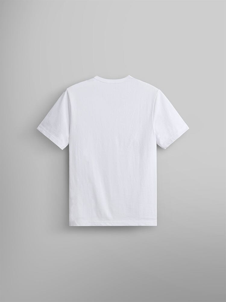 The Alpha Camo Logo Tee by Alpha Industries in white, is displayed on a light gray wall, presented from the back.