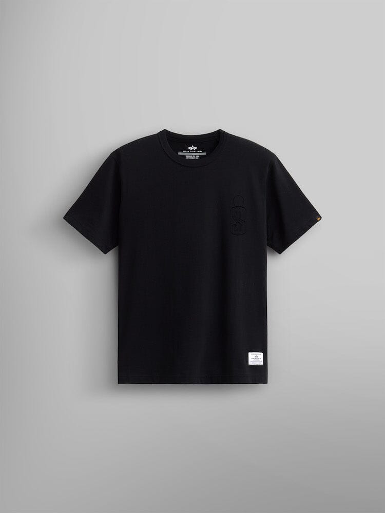 Alpha Dog Tag Tee by Alpha Industries, is a black short-sleeve t-shirt showcased on a plain gray background. It features a small screen print graphic emblem and label near the hemline.