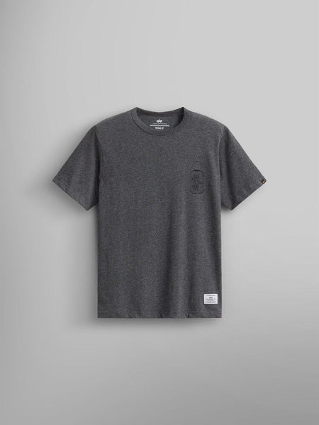 The Alpha Dog Tag Tee by Alpha Industries, showcases a unisex style in dark charcoal heather. It features a small black logo on the left chest and a white label at the bottom.