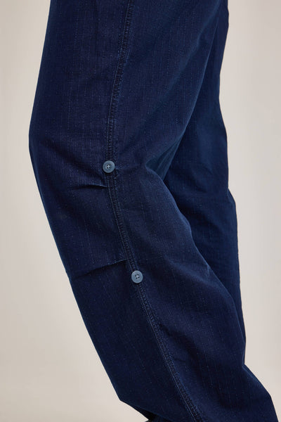 Close-up of the Alpha X Lee Snowpant by Alpha Industries, crafted from durable dark blue ripstop cotton with a subtle pinstripe pattern and adorned with two blue buttons on the fabric.