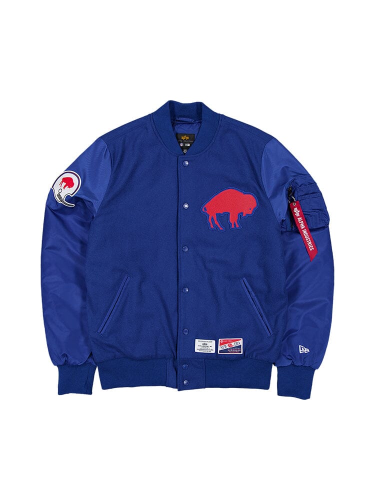 Pacific blue varsity jacket with a wool outer shell featuring a red buffalo emblem on the chest, an NFL bomber-jacket-inspired football helmet patch on the sleeve, and team patches at the hem and cuff. This piece is known as the Buffalo Bills X Alpha X New Era MA-1 Bomber Jacket by Alpha Industries.