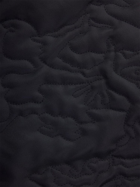 Close-up of fabric from the Alpha Industries Camo Quilted MA-1 Bomber Jacket, showcasing a black quilted camo pattern with an abstract design.