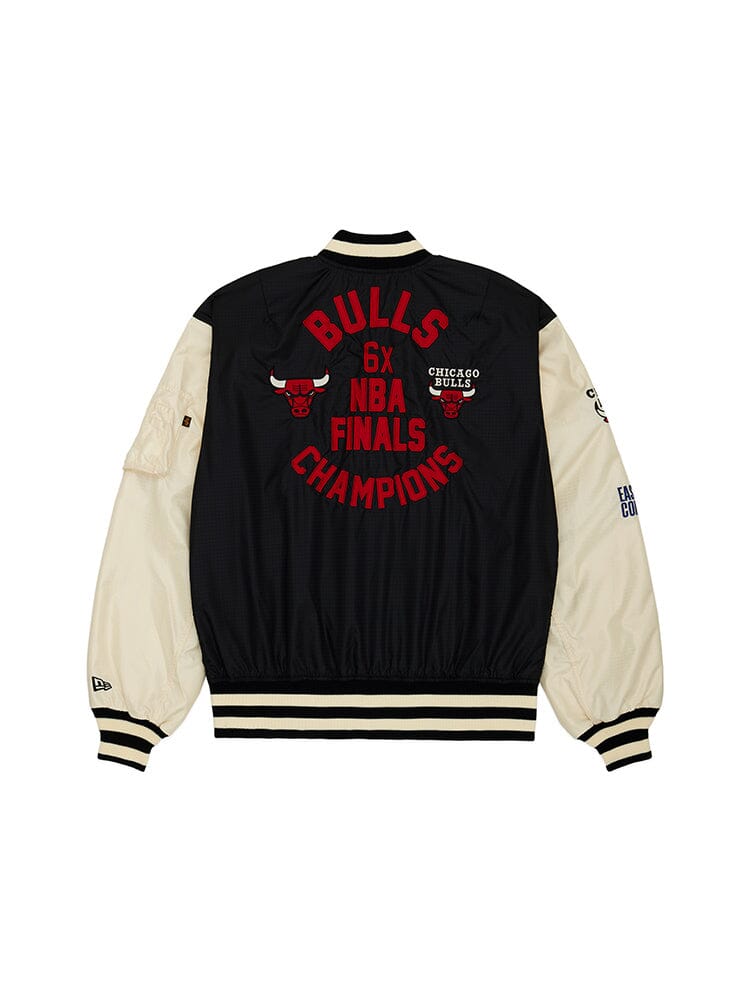 The Chicago Bulls X Alpha X New Era L-2B Bomber Jacket by Alpha Industries is a black and white varsity jacket featuring Bulls 6x NBA Finals Champions embroidery on the back and team patches in a special collaboration with New Era.