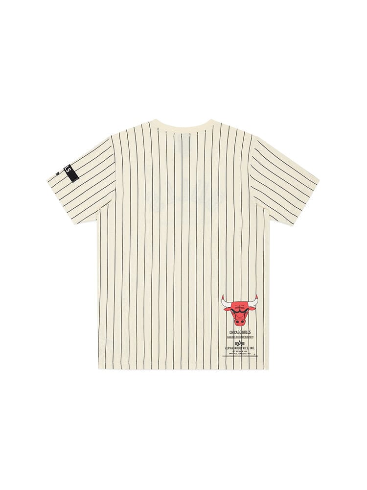 Alpha Industries and NE-NBA present the Chicago Bulls x Alpha x New Era Tee: a white T-shirt with team color pinstripes, vertical black stripes, and a red bull graphic with text near the hem.