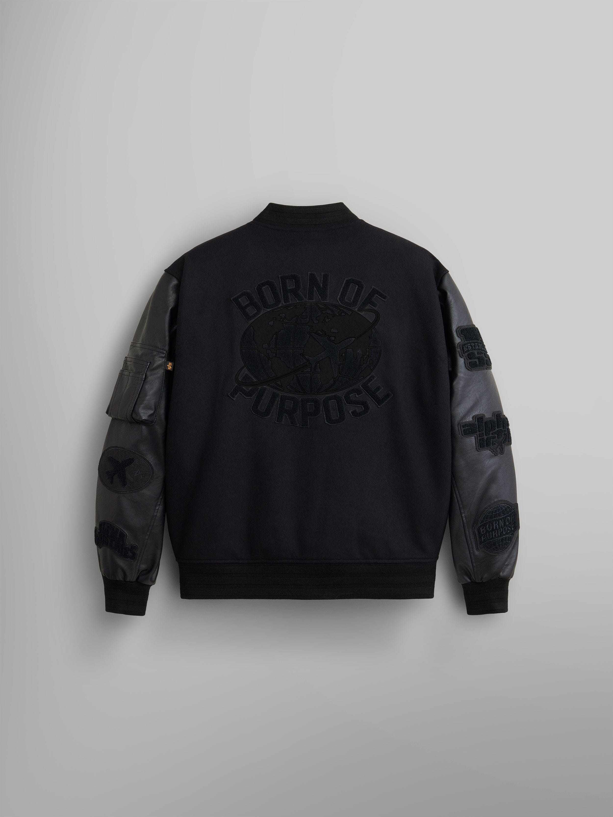 Back view of the Faux Leather MA-1 Varsity Bomber Jacket by Alpha Industries, in black with Born of Purpose text on the back.