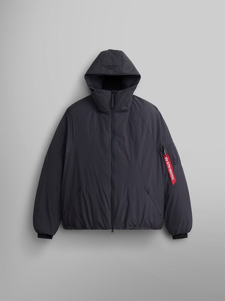 Introducing the Alpha Industries Insulated Hooded Parka, a stylish black parka with a front zipper, enhanced by a red Remove Before Flight tag on the sleeve. Crafted with water-resistant materials for superior protection.