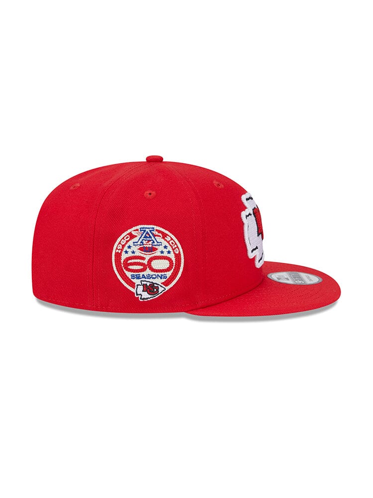 Introducing the Kansas City Chiefs x Alpha x New Era 950 Cap, a stylish New Era snapback from Alpha Industries. This cap features a flat brim, button on top, and proudly showcases the team logo alongside a 60 seasons patch on the side. It's perfect for any fan looking to combine style and heritage.