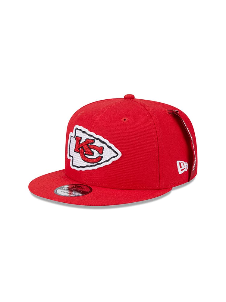 This red Kansas City Chiefs x Alpha Industries x New Era 950 cap features the team's logo with stylized letters inside an arrowhead shape on the front, designed by New Era for fans who appreciate quality and style.