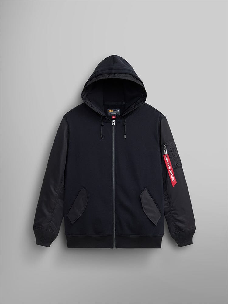 The Alpha Industries MA-1 Zip Up Hoodie in black, crafted from soft French terry fabric, includes two front pockets, flight nylon sleeves, a red tag on the left sleeve, and a hood.