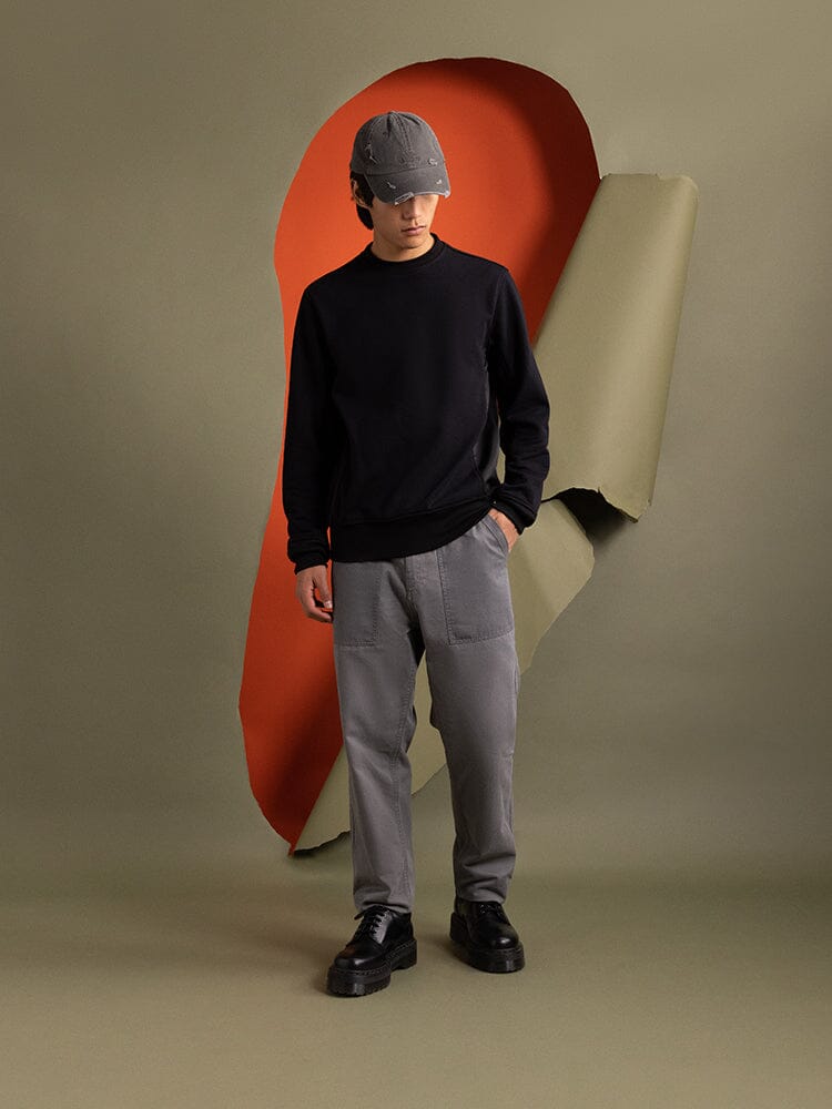 An person wearing an Mixed Media Crewneck Sweatshirt in black by Alpha Industries.