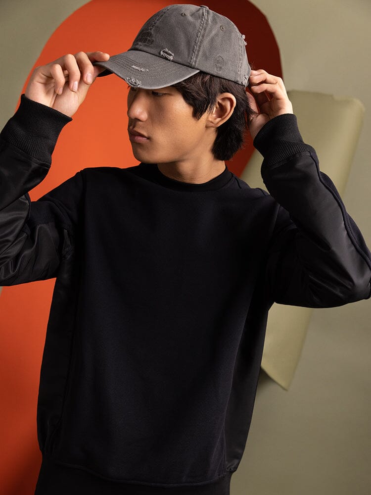 A person wearing a Mixed Media Crewneck Sweatshirt in black by Alpha Industries.