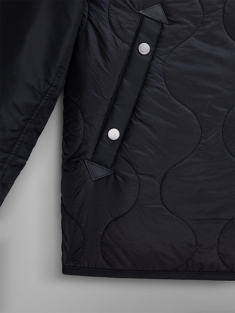 Close-up of the Mixed Media Quilted Utility Jacket by Alpha Industries, featuring black nylon ripstop fabric with visible buttons and stitching.