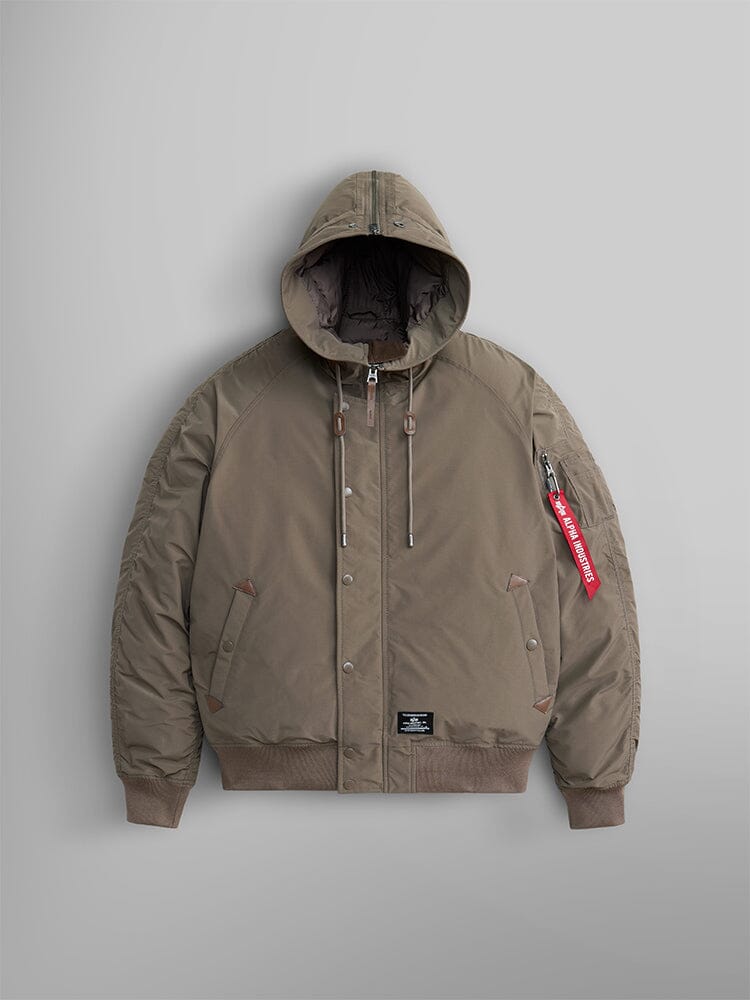 N-2B Altitude Parka, in coyote brown, by Alpha Industries features an adjustable split hood and a red tag on the sleeve. This water-resistant bomber jacket comes with snap buttons and a front zipper closure.