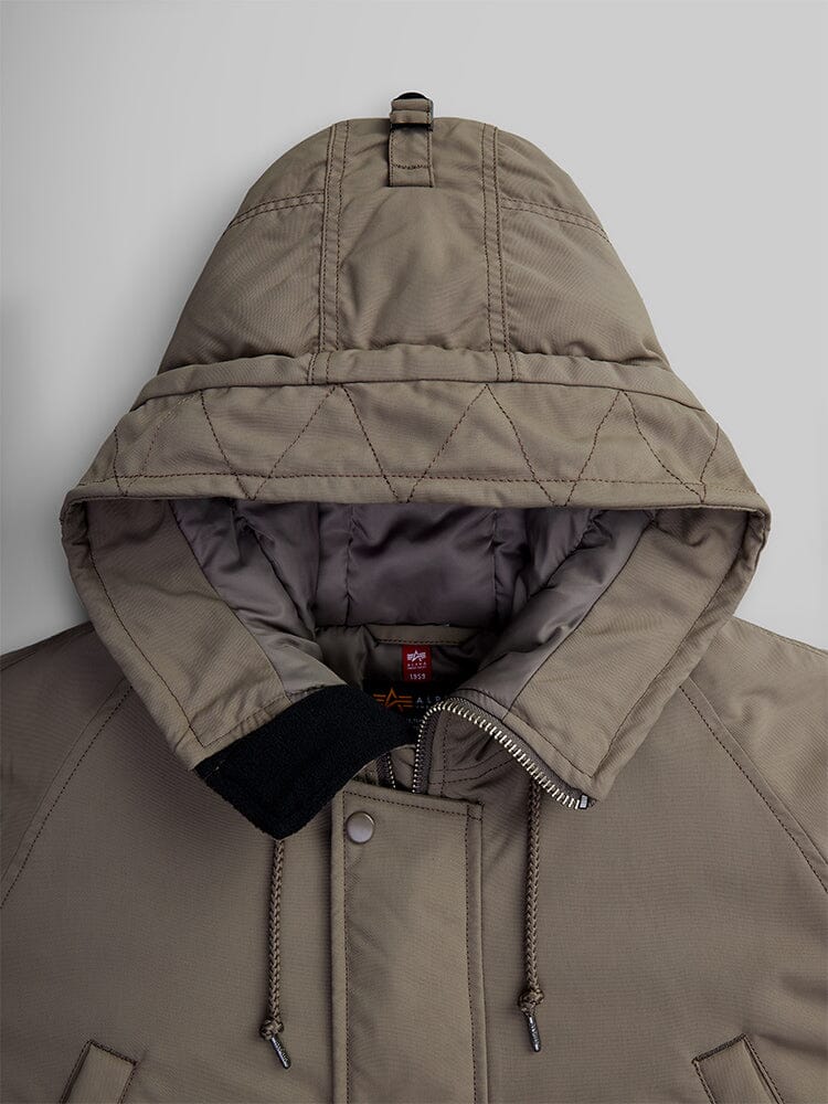 Close-up view of the N-3B Altitude Mod Parka in brown by Alpha Industries, a quilted parka with a hood, front zipper, and snap buttons, designed to be water-resistant.