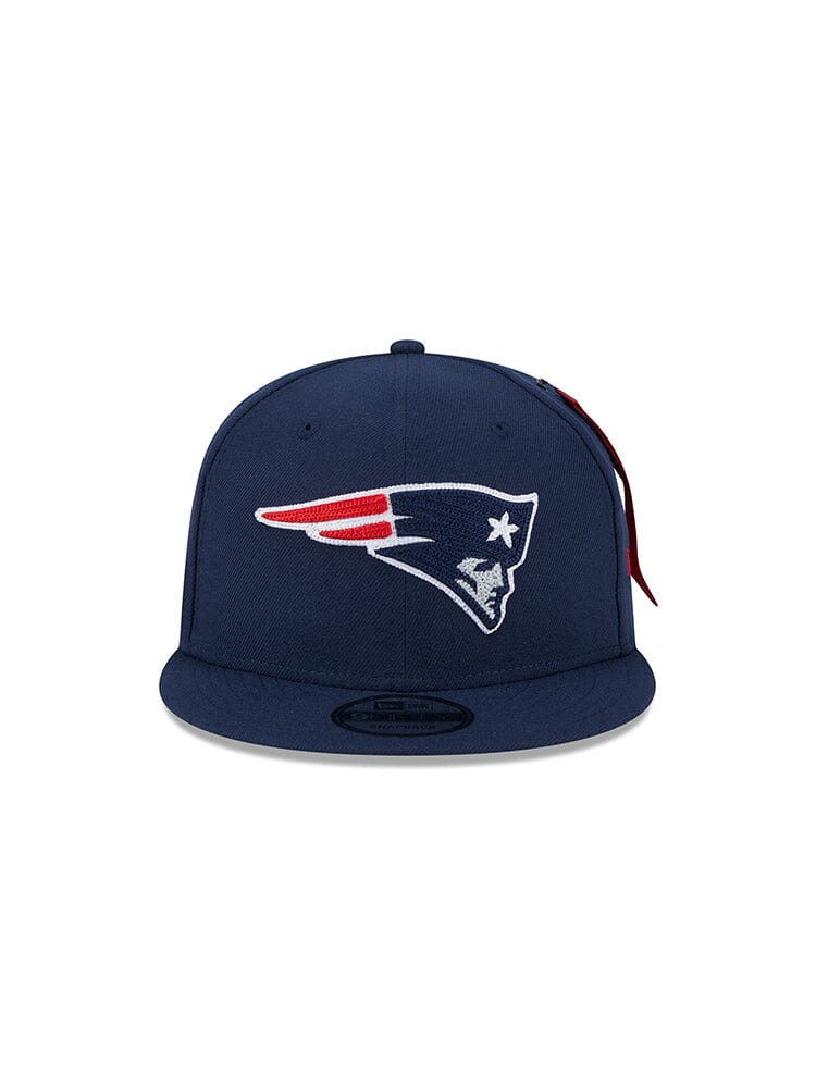 The New England Patriots x Alpha x New Era 950 Cap from Alpha Industries showcases a stylized head in a tricorn hat with red, white, and blue colors. Its snapback design offers a comfortable fit for any style enthusiast.