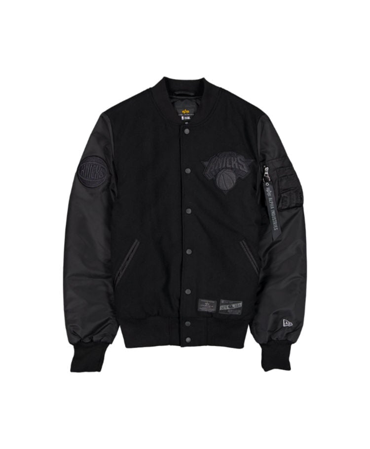 The New York Knicks x Alpha x New Era Wool Varsity MA-1 Bomber Jacket by Alpha Industries features black faux leather sleeves, the iconic New York Knicks logo on both the chest and sleeve, a convenient zipper pocket on the left arm, and a classic button closure.