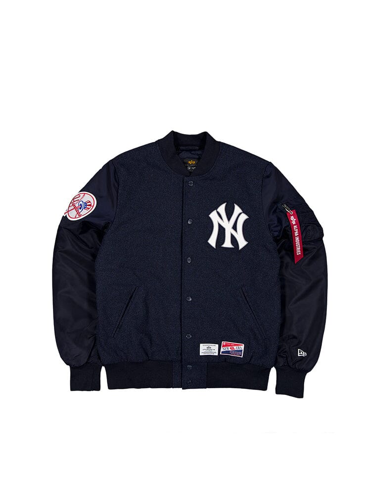 Introducing the New York Yankees X Alpha X New Era MA-1 Bomber Jacket from Alpha Industries. This stylish jacket comes in replica blue with contrasting black sleeves and features the iconic New York Yankees logo on the front. It also includes an emblem patch on the left sleeve. Designed with quilted lining, this jacket provides both comfort and style, perfectly capturing the essence of a classic MA-1 Bomber Jacket while showcasing MLB team pride for true fans.