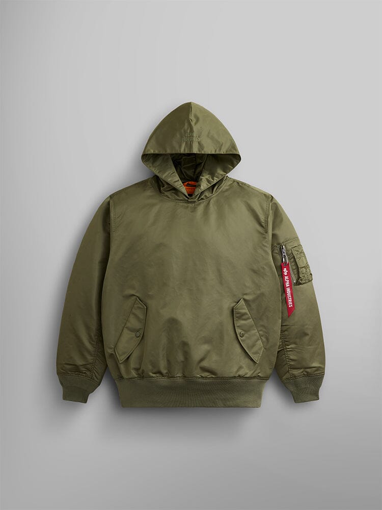 The Pull-Over MA-1 Jacket Hoodie by Alpha Industries in OG-107 Green is made from iconic flight nylon and features utility pockets on the front, along with a zipped sleeve pocket adorned with a red tag.