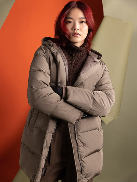 A person with red hair, wearing an Alpha Industries Sierra Convertible Jacket W in a water-resistant brown finish over a dark sweater.