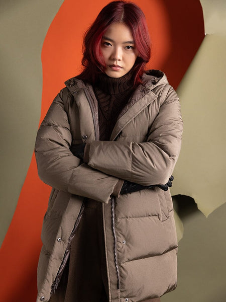 A person with red hair stands wearing the Sierra Convertible Jacket W from Alpha Industries, water-resistant arms crossed, looking forward.