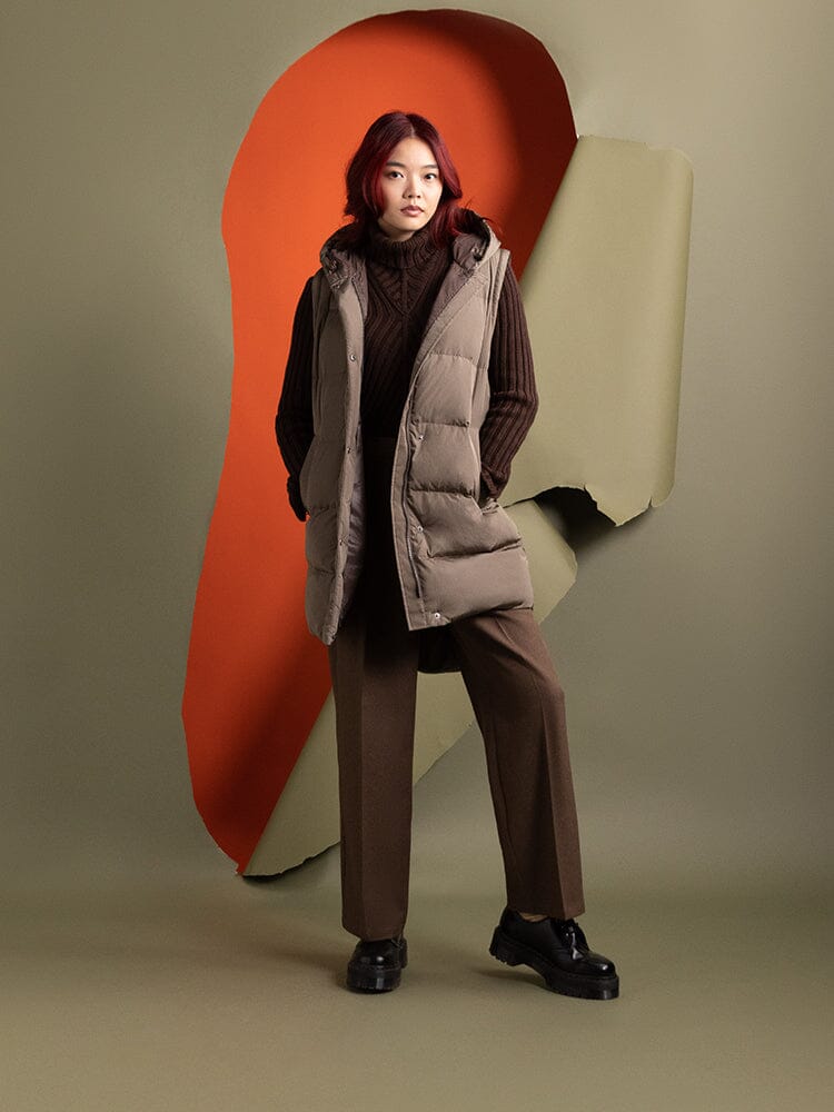 A person with red hair is wearing the Sierra Convertible Jacket W by Alpha Industries. The outfit is completed with brown pants and a sweater.