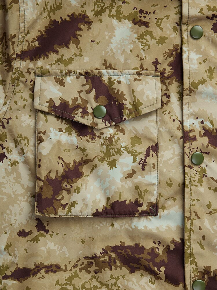 Close-up of the Tactical M-65 Field Jacket, a camouflage-patterned fabric field coat from Alpha Industries, showcasing a front pocket and green buttons.