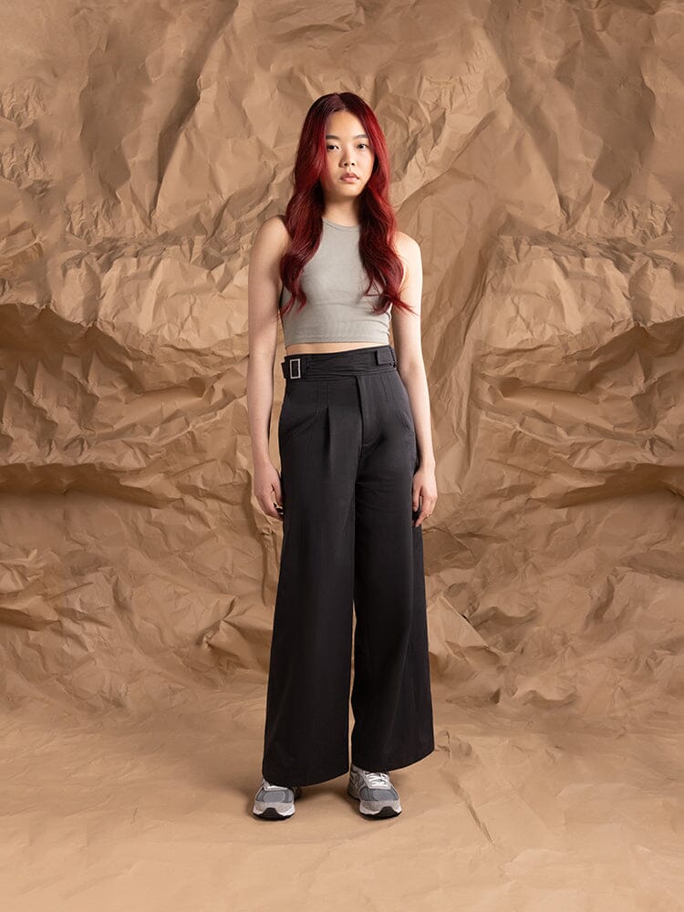 A person wearing the Women's Gurkha Wide Leg Trouser in black by Alpha Industries, and gray sneakers.