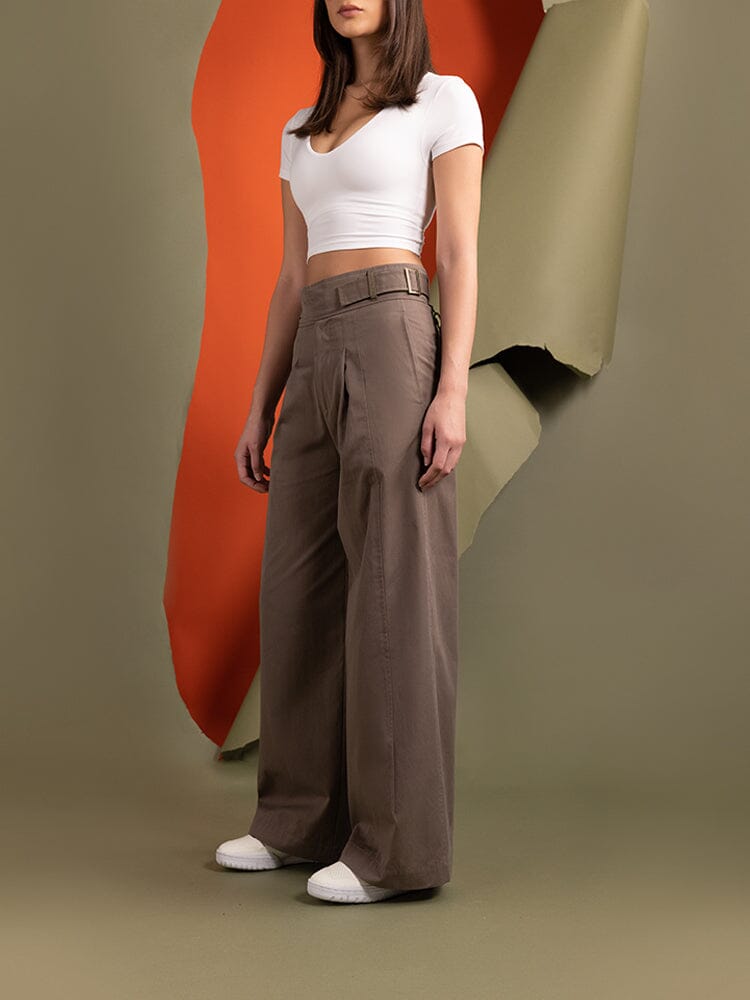 A person stands wearing a white crop top and the Women's Gurkha Wide Leg Trouser in brown from Alpha Industries.