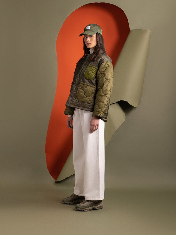 Side view of a person wearing a Women's Insulated Chore Coat in green by Alpha Industries.