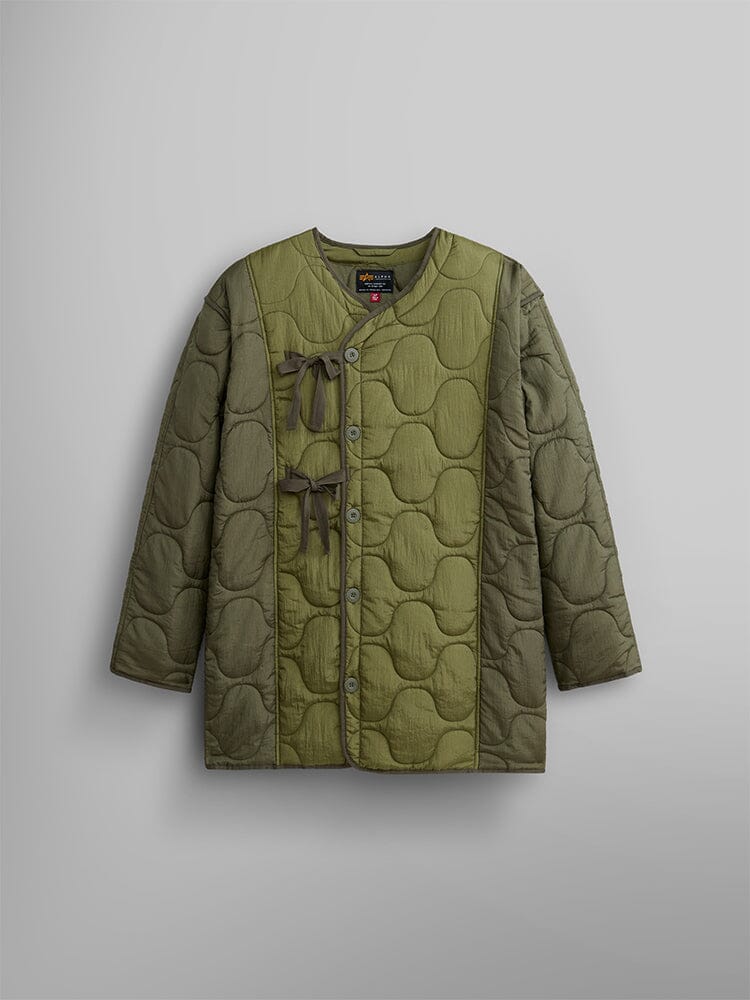 The Alpha Industries Women's Mixed Media Quilted Long Liner in OG-107 Green features a round neckline, asymmetrical button closures, and fabric side ties.