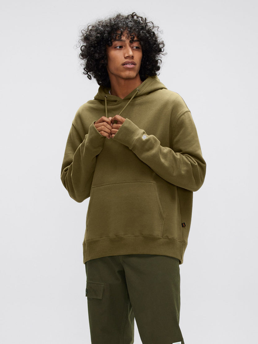 A person wearing the Alpha Hoodie in olive green from Alpha Industries, Inc., featuring a subtle applique design, paired with matching cargo pants made from soft cotton fabric.