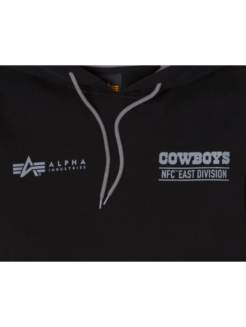 A close-up showcases the Dallas Cowboys x Alpha x New Era Hoodie, featuring the Alpha Industries logo on the left and the Cowboys NFC East Division emblem on the right. The design is enhanced by gray drawstrings.