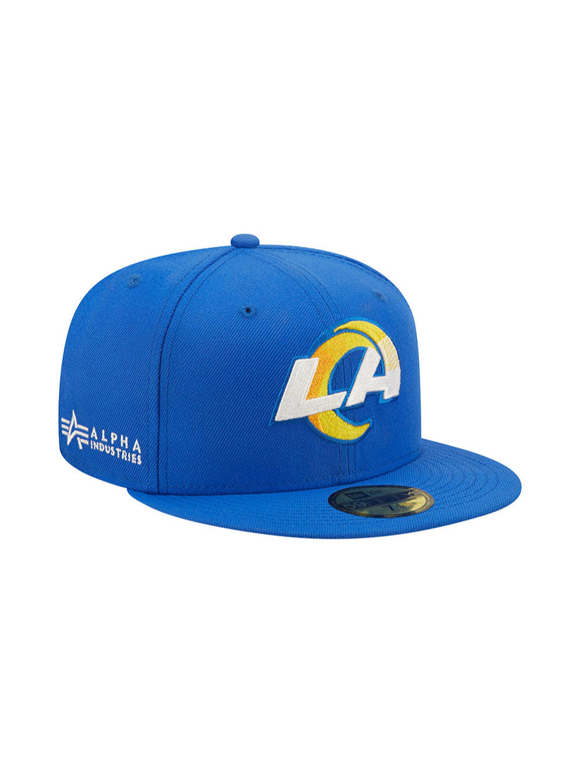 Introducing the Los Angeles Rams x Alpha Industries x New Era 59Fifty Fitted Cap: This blue cap showcases the LA Rams logo with eye-catching yellow accents on the front. The Alpha Industries logo is stylishly placed on the side, and it features New Era's signature design for a classic look.