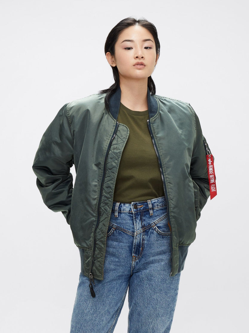 Wearing the MA-1 Battlewash Bomber Jacket by Alpha Industries, Inc., this individual complements their look with a casual green shirt and jeans, showcasing effortless style.