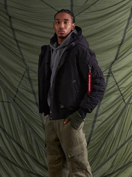 With confidence, the individual poses wearing the N-2B Altitude Parka in black from Alpha Industries.