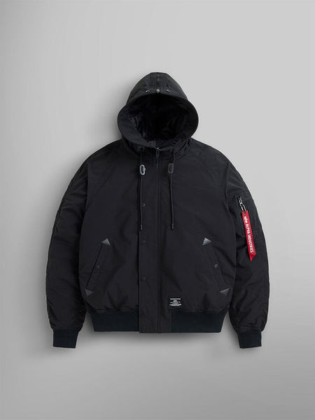 N-2B Altitude Parka, in black, by Alpha Industries features an adjustable split hood and a red tag on the sleeve. This water-resistant bomber jacket comes with snap buttons and a front zipper closure.